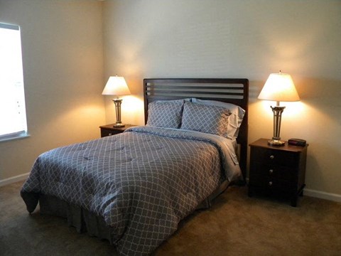 a bedroom with a bed and two lamps