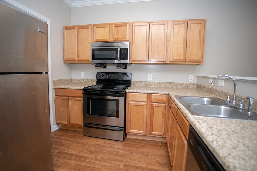 a kitchen with wooden cabinets and stainless steel appliances
