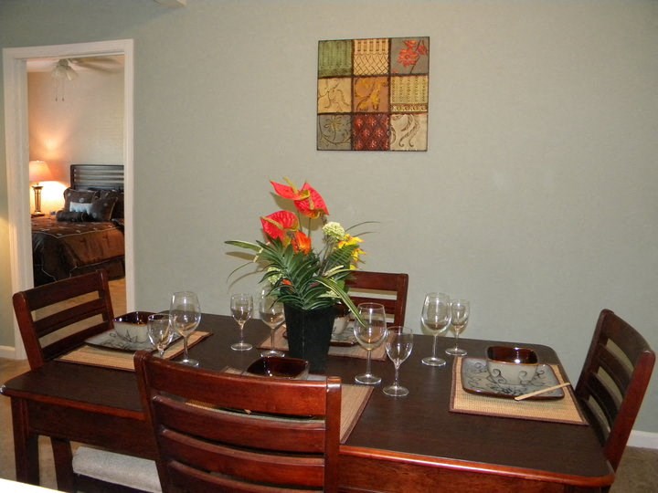 a dining room table with a vase of flowers