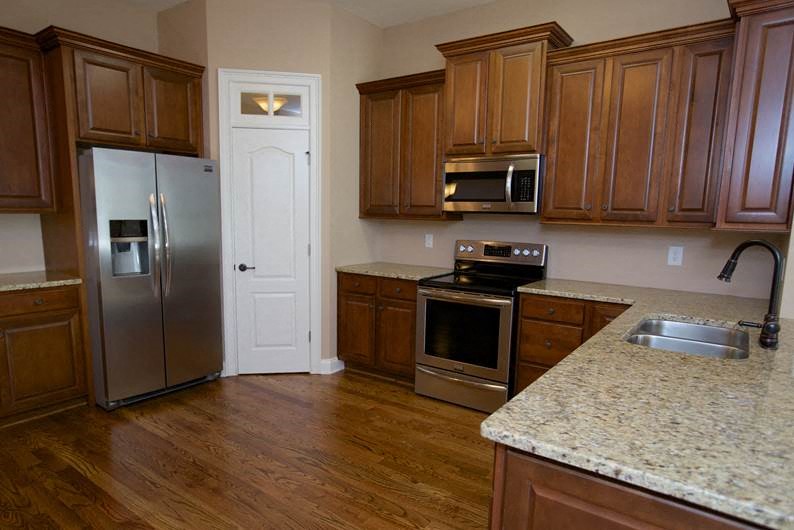 a kitchen with wooden cabinets and stainless steel appliances