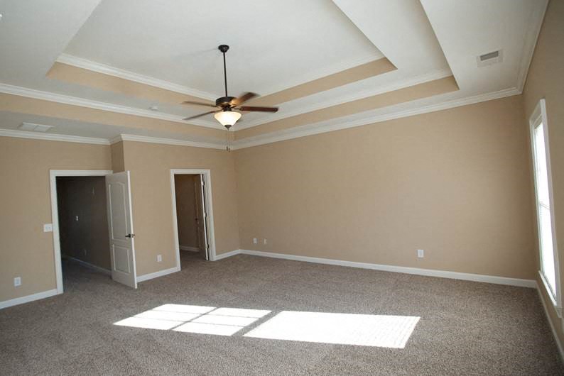 an empty living room with a ceiling fan