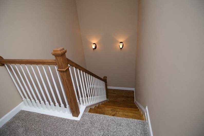 a staircase in a house with two lights on the wall