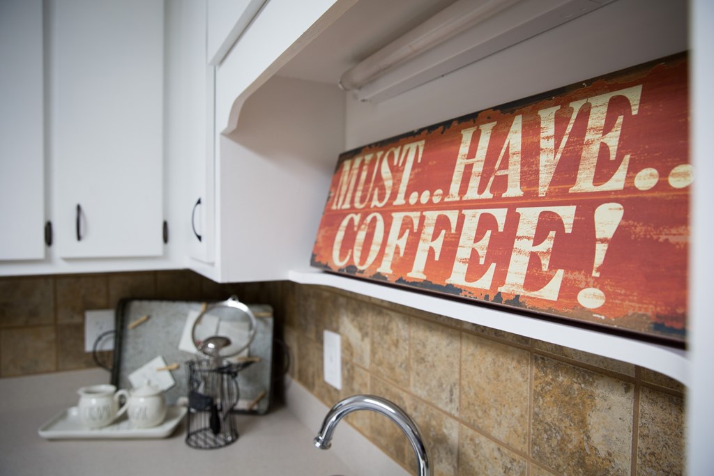 an old sign on the wall above a kitchen sink