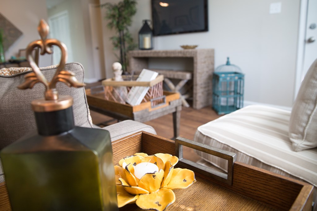 a living room with a bed and a table with a perfume bottle