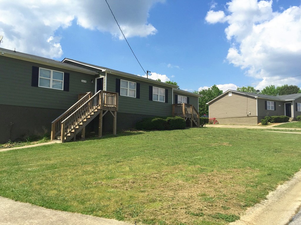 a green house with a yard in front of it