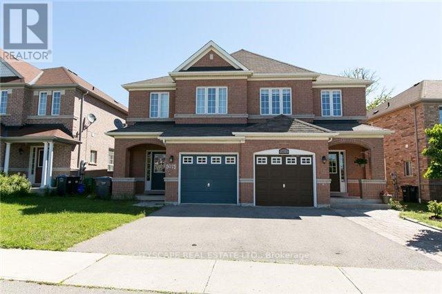 A large brick house with a driveway in front.