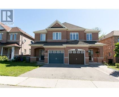 A large brick house with a driveway in front.