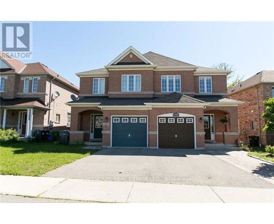 A large brick house with a driveway in front.