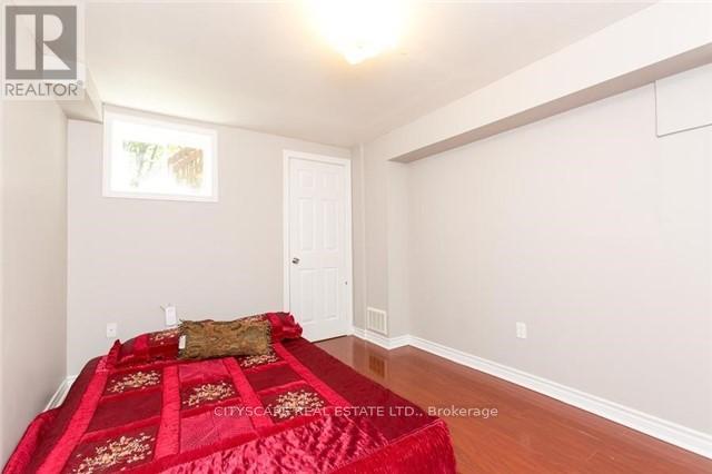 A bedroom with a red bedspread and a white door.