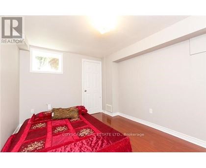 A bedroom with a red bedspread and a white door.