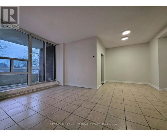 A spacious room with tiled flooring and white walls.