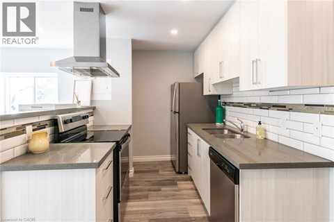 A modern kitchen with white cabinets and stainless steel appliances.