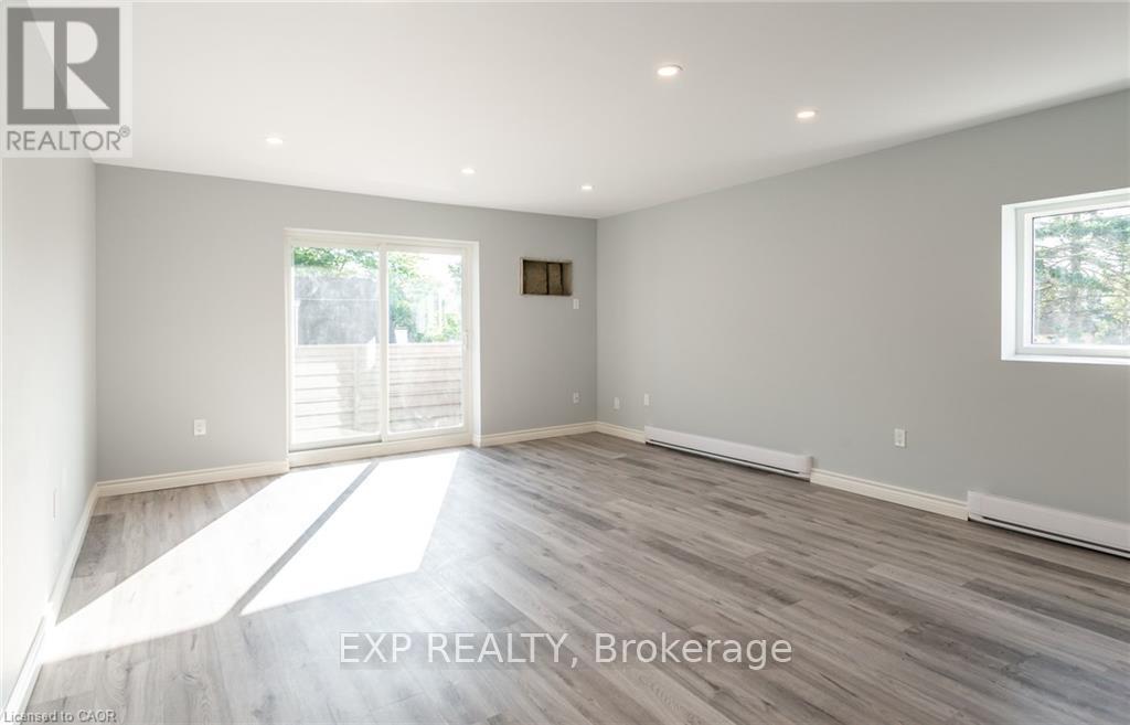 A room with wooden flooring and a large window.