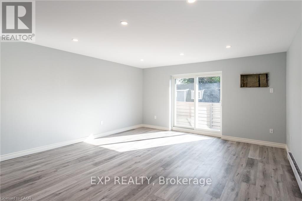 A spacious room with a sliding glass door leading to a balcony.