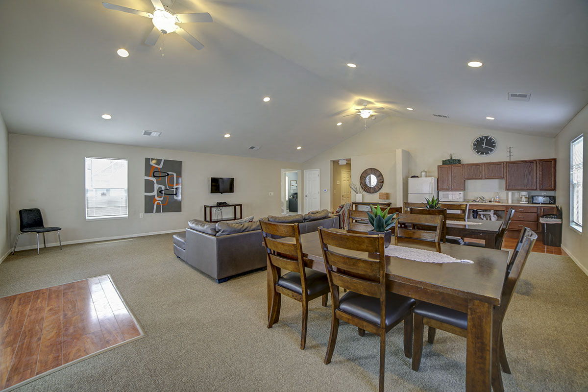 a living room and dining room with a table and chairs