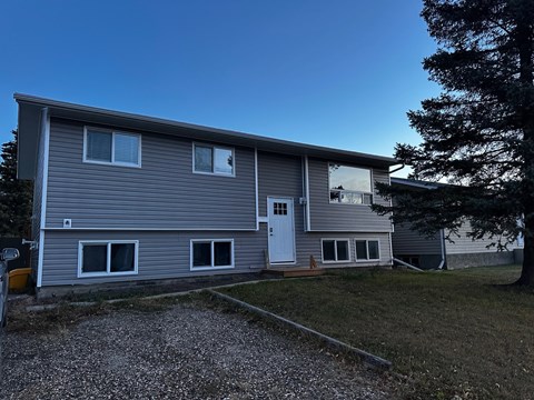 A grey house with a white door and windows.