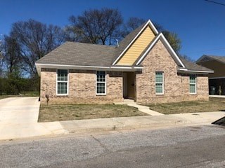 A small house with a yellow roof and stone walls.
