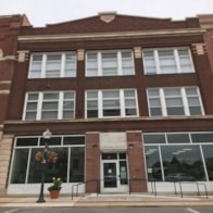 A red brick building with a black door and windows.