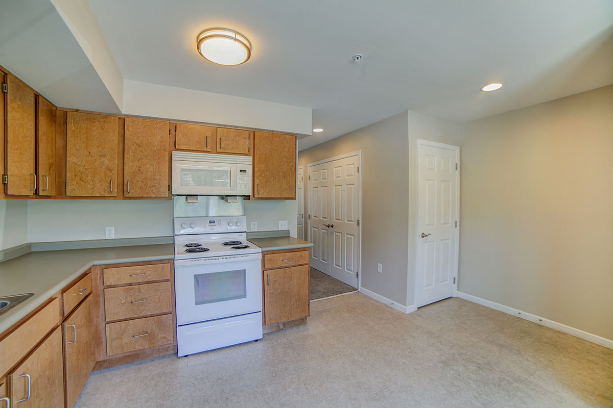 a kitchen with white appliances and wooden cabinets