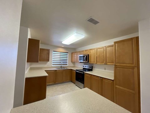 A kitchen with wooden cabinets and a white countertop.