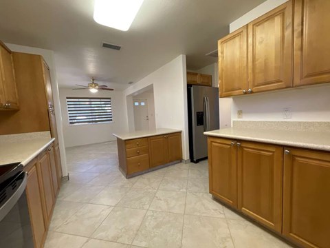 A kitchen with wooden cabinets and a refrigerator.