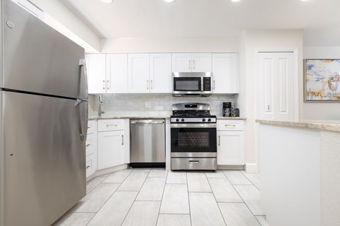 A modern kitchen with stainless steel appliances and white cabinets.