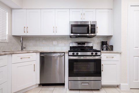 A kitchen with white cabinets and a black stove top oven.