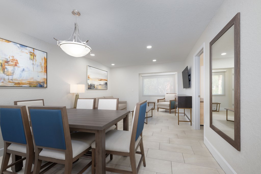 A dining room with a wooden table and blue chairs.