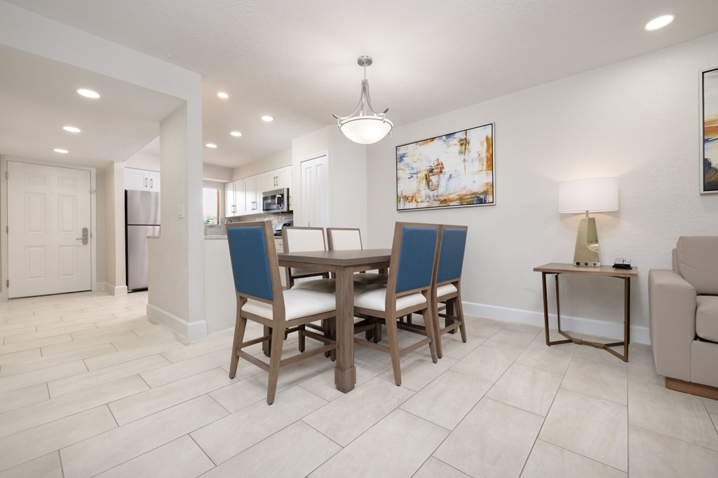 A dining room with a table and chairs.