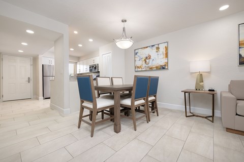 A dining room with a table and chairs.