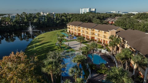 A large building with a pool and a fountain in front of it.