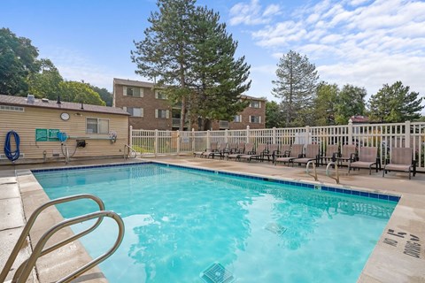 A swimming pool with a ladder and a fence around it.