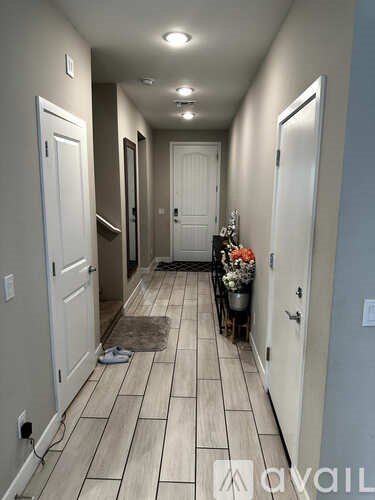 A hallway with a tiled floor and white doors.
