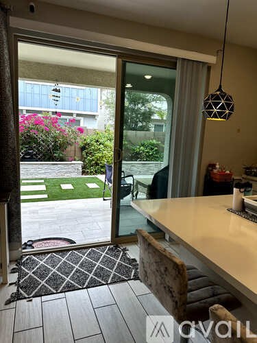 A patio area with a table and chairs is visible through an open sliding glass door.
