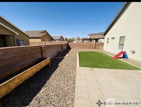 A residential area with a gravel path and a grassy area.