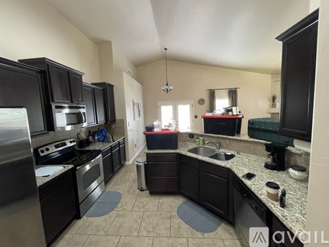 A kitchen with black cabinets and granite countertops.
