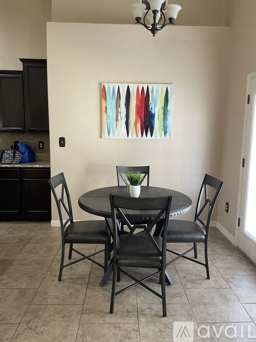 A dining room with a round table and four chairs.