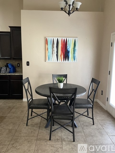 A dining room with a round table and four chairs.