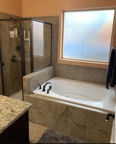 A bathroom with a tub and a walk in shower.