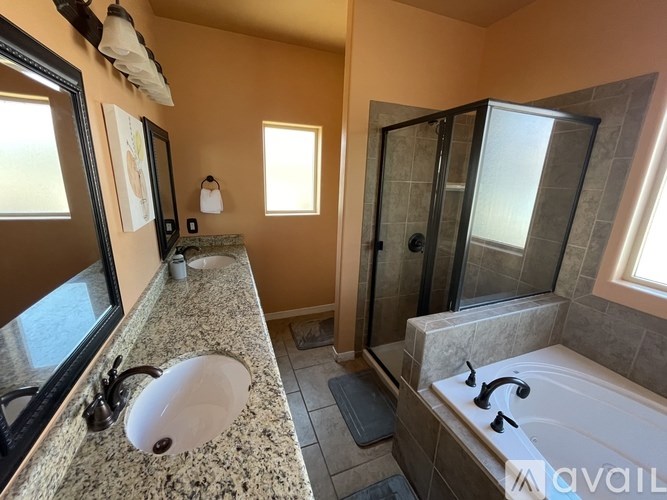 A bathroom with a sink, mirror, and bathtub.