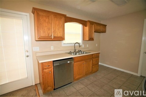 A kitchen with wooden cabinets and a stainless steel dishwasher.
