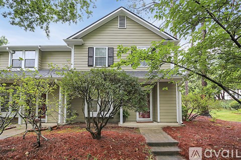 A house with a front yard and a tree.
