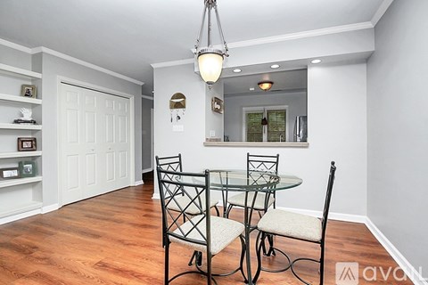 A dining room with a glass table and chairs.