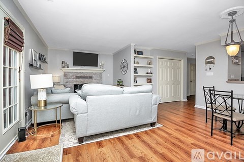 A living room with a grey couch and a fireplace.