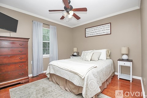 A bedroom with a bed, nightstand, and dresser.