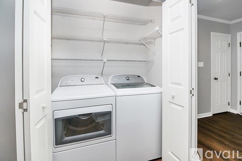 A white dryer and washer are installed in a laundry room.