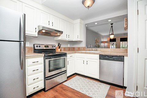 A kitchen with white cabinets and stainless steel appliances.