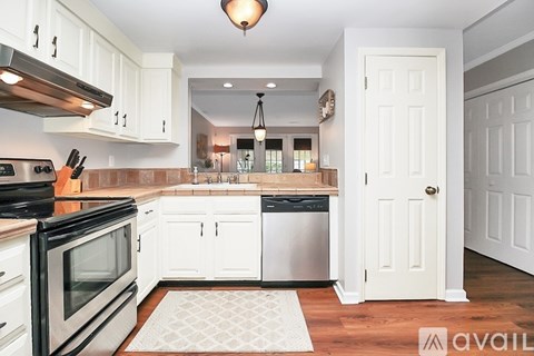 A kitchen with white cabinets and a black stove top oven.