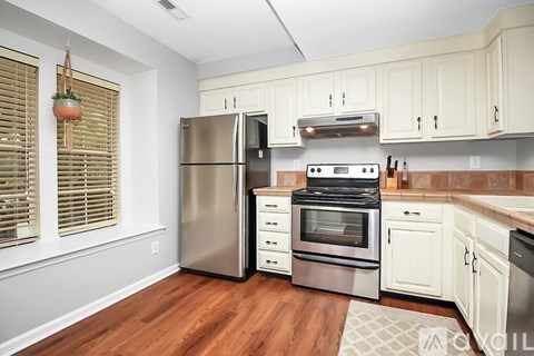 A kitchen with a stainless steel refrigerator, oven, and microwave.