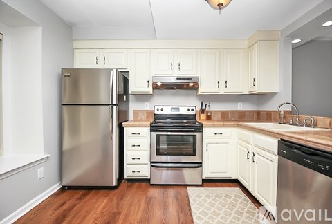 A kitchen with a stainless steel refrigerator, oven, and sink.